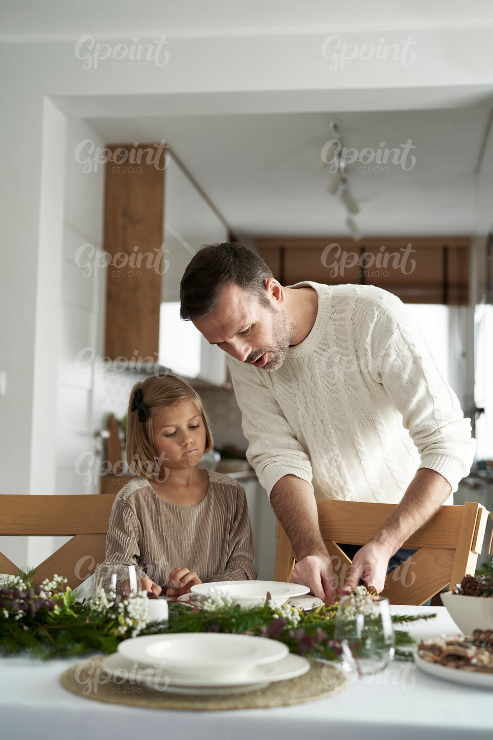 Caucasian father and daughter lying the table at Christmas time