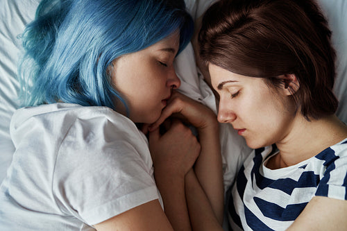 Close up of lesbian couple sleeping on bed