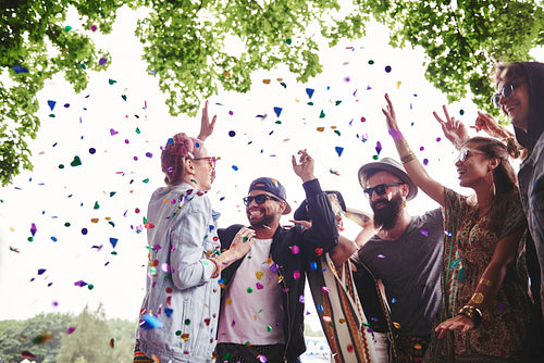 Group of friends dancing in confetti