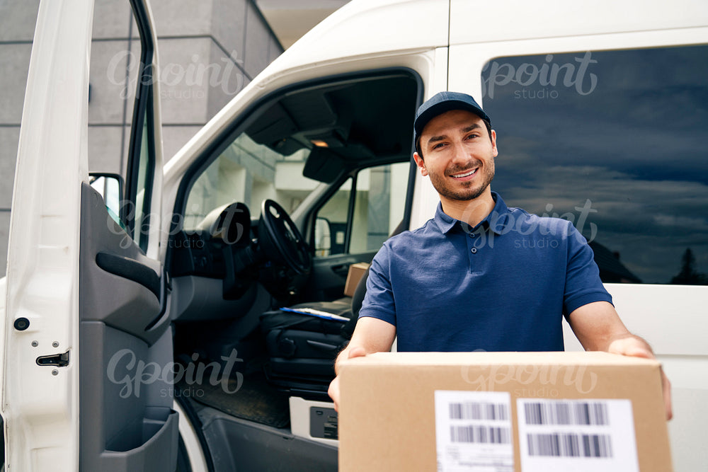 Portrait of a smiling courier giving a package
