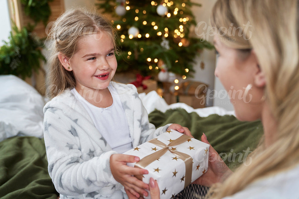 Little girl giving Christmas present for her mum