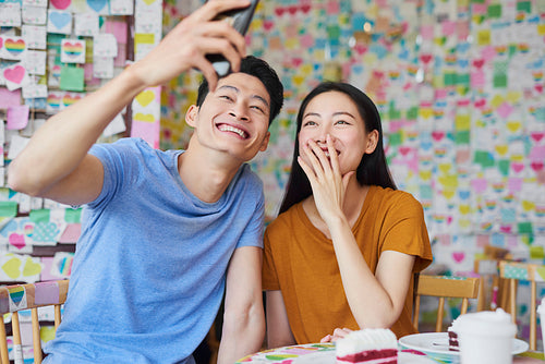 Vietnamese couple making a selfie in a cafe
