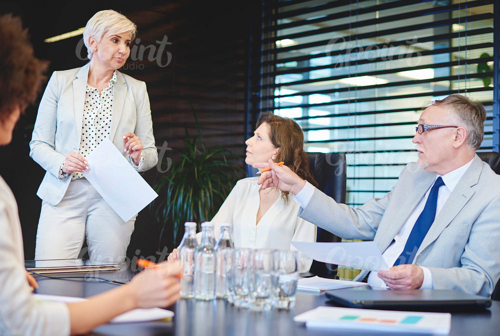 Mature woman listening to coworkers concepts