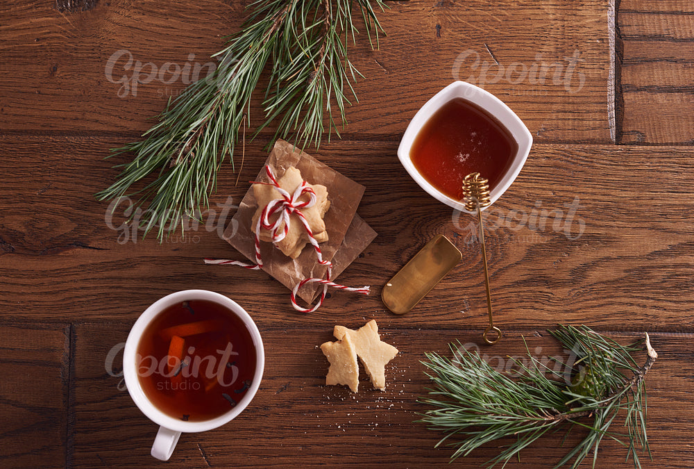 Hot tea with honey and lemon next to gingerbread cookies