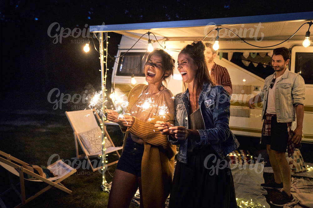 Happy friends enjoying time while holding sparklers