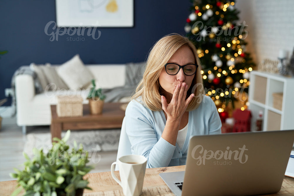 Mature woman sending kisses during video conference at home