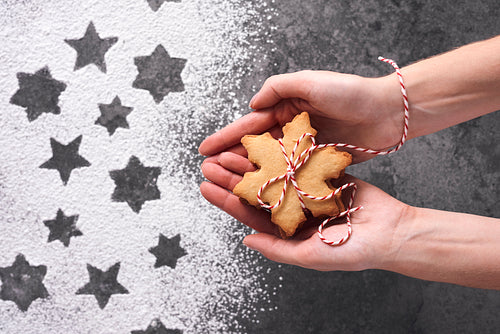 Close up of woman’s hands holding gingerbread cookies