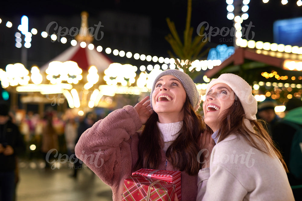 Women outdoors with Christmas gift looking away