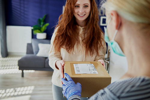 Woman receiving a parcel from a delivery person
