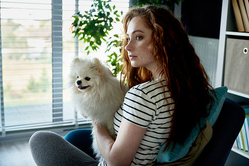 Redhead woman with a dog in the living room