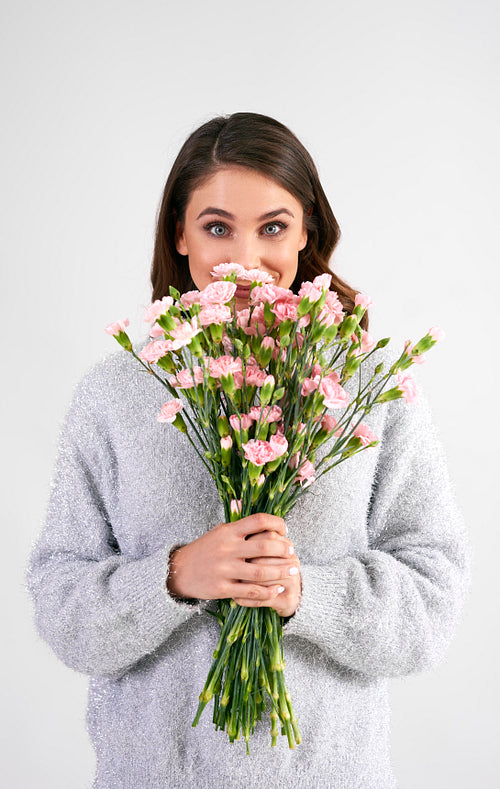 Portrait of beautiful woman holding bunch of flowers