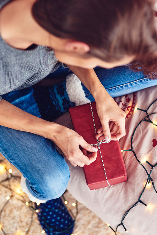Young woman packaging holiday gift