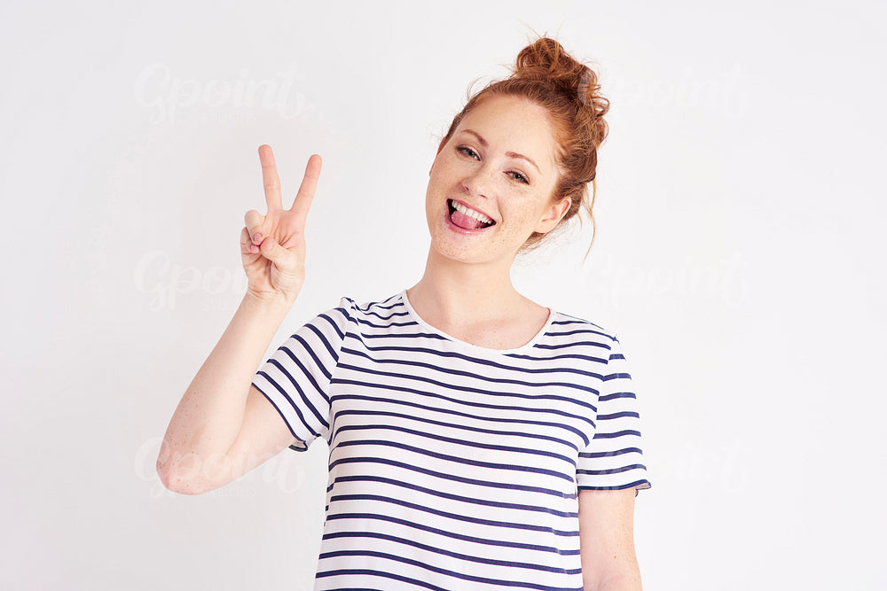 Peace sign made by young woman at studio shot
