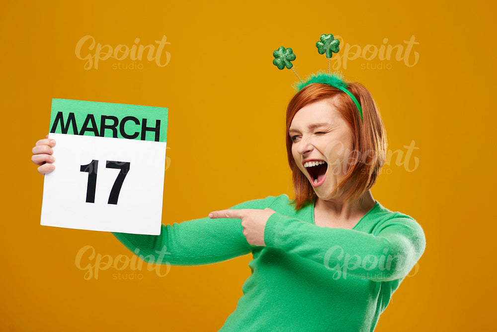 Playful woman pointing at Saint Patrick's Day calendar