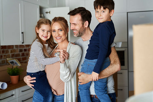 Portrait of smiling family with children in a new apartment