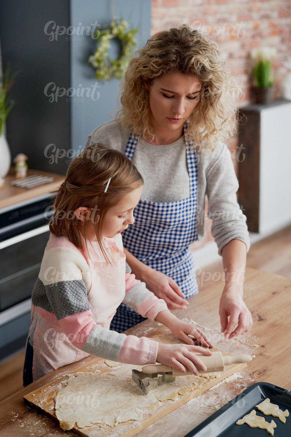 Little girl making Easter cookies with mother