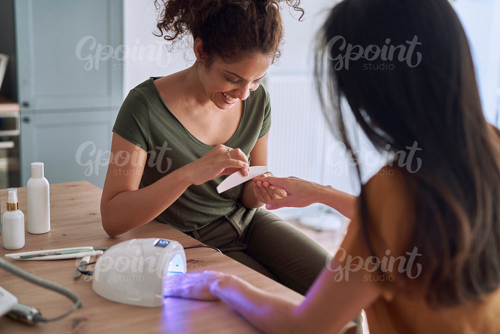 Happy women making nail beauty treatments at home