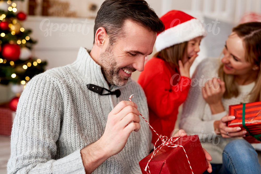 Happy man opening Christmas gift