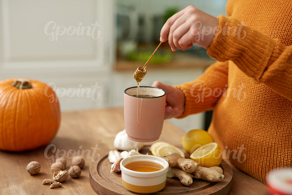 Woman making hot tea with honey