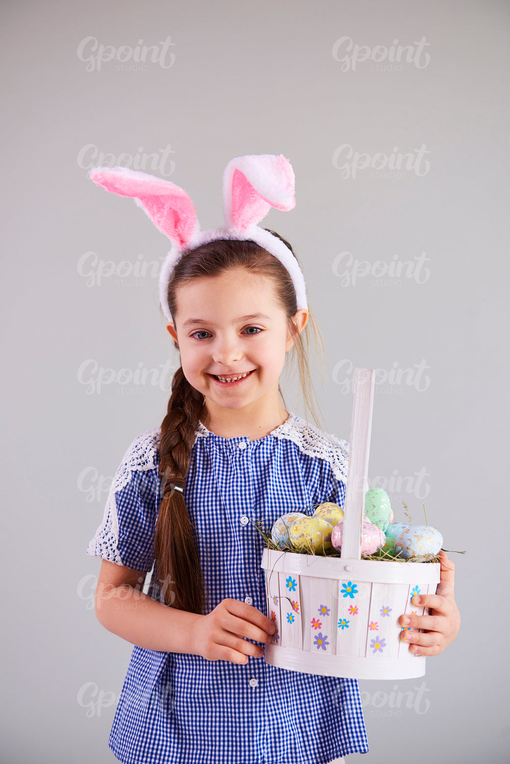 Smiling girl holding a basket of easter eggs