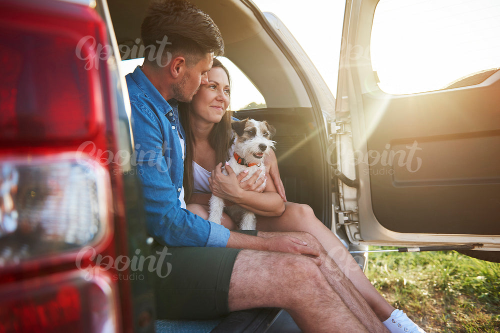 Loving couple with dog enjoying the view in summertime