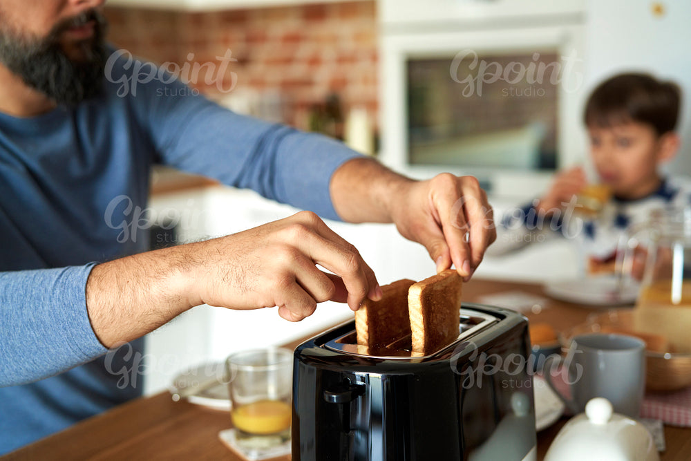 Close up of man pulling toast from a toaster
