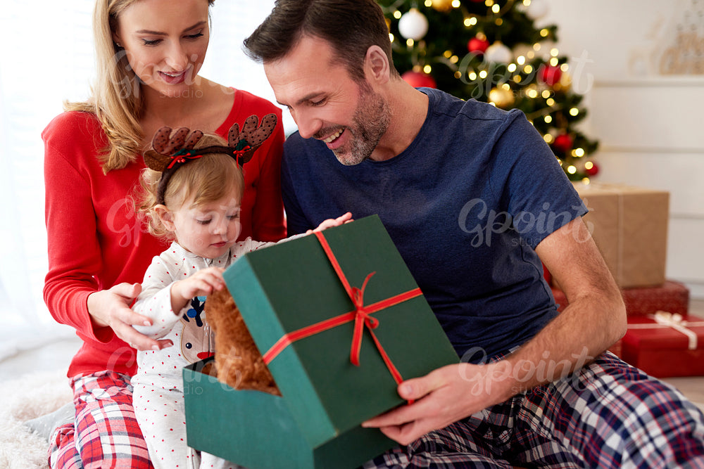 Family opening Christmas presents in the bed