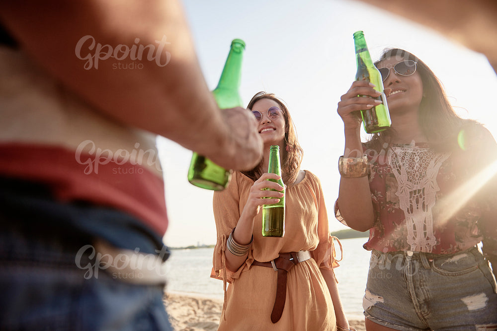 Happy women drinking beer on the beach party