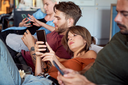 Friends focused on smart phones at party