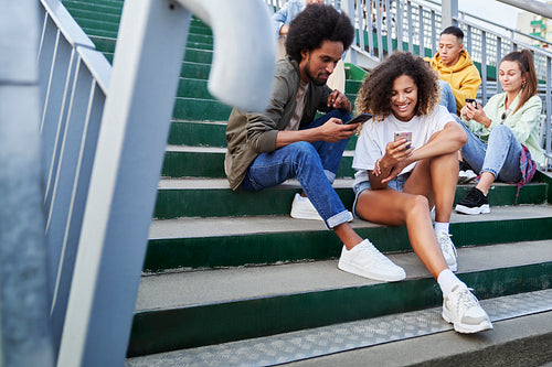 Group of young people sitting with your mobile phones outdoors