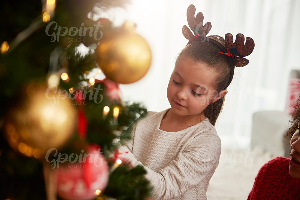Charming girl decorating the Christmas tree