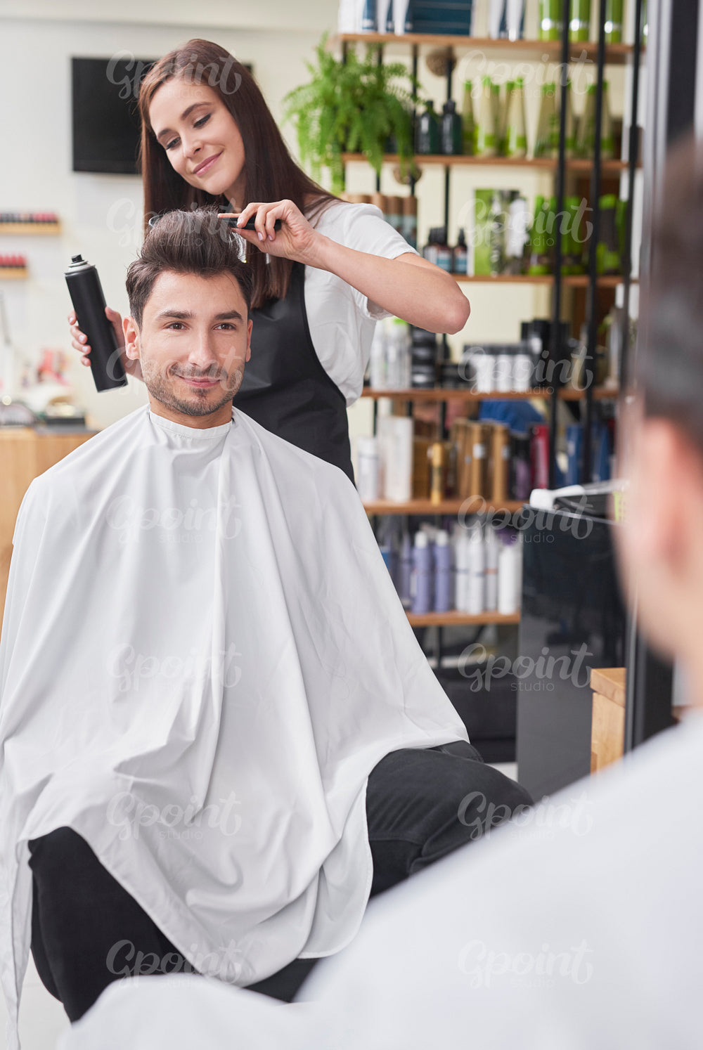 Smiling male customer sitting in hair salon