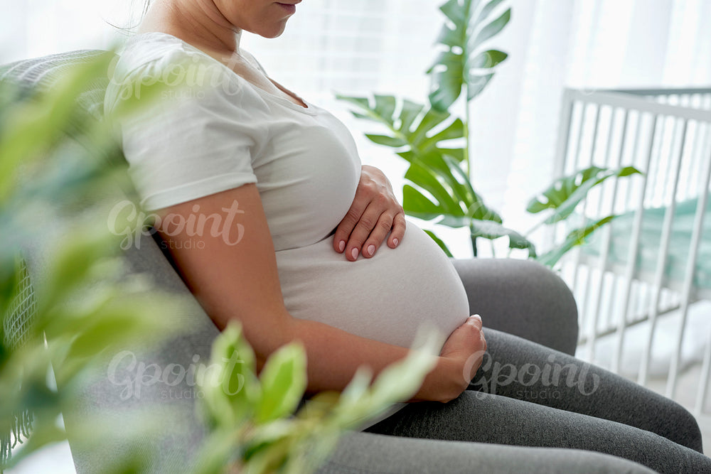 Pregnant woman sitting comfortably in the armchair