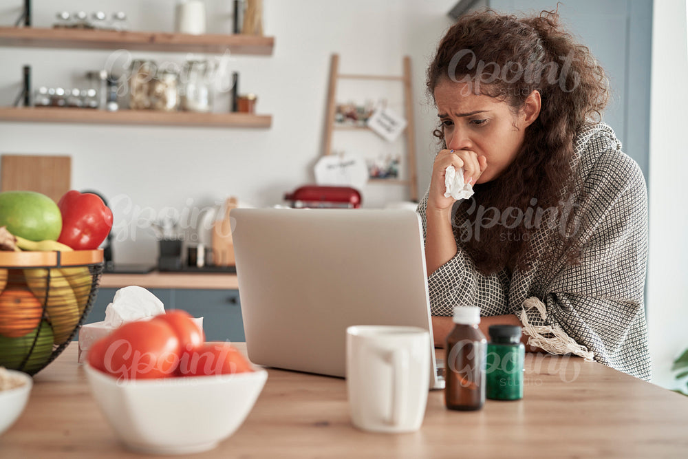 Sick woman using laptop at home