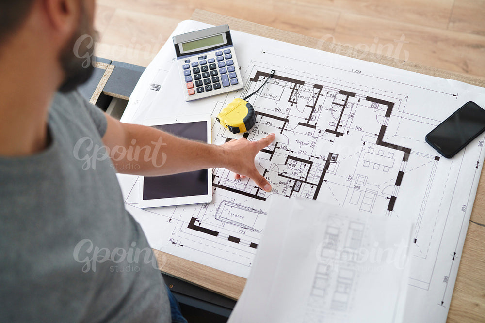 Man showing a finger on blueprints