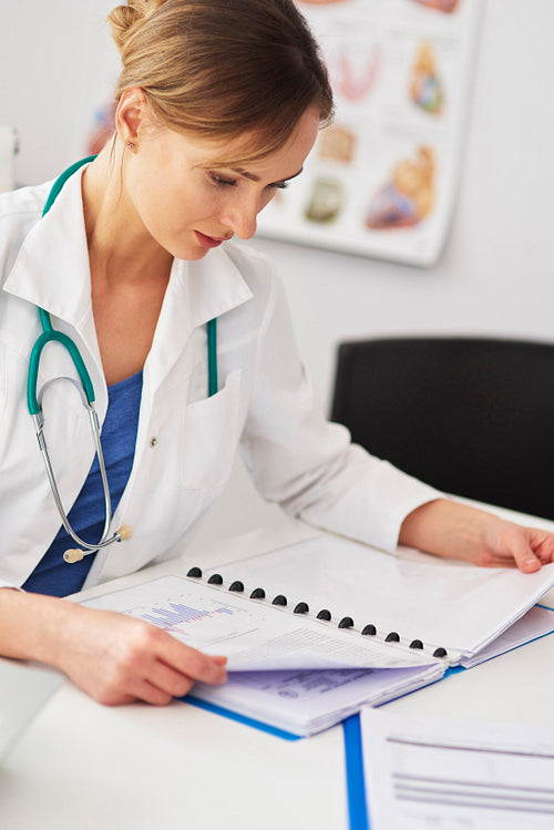 Female doctor examining the medical record
