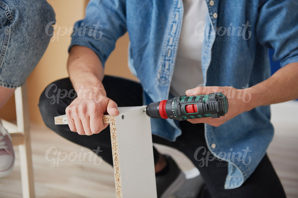 Unrecognizable man installing furniture for new house