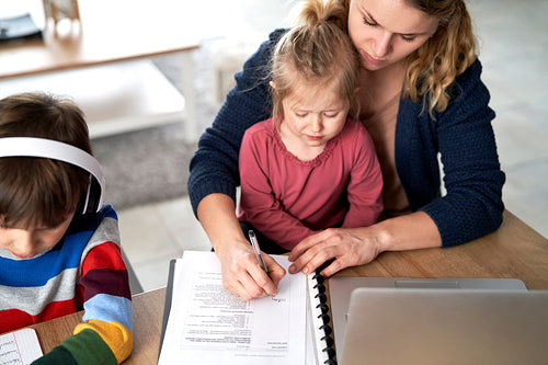 Top view of mother working from home with young children