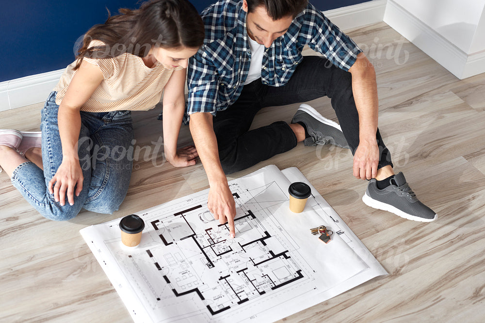Couple looking at blueprint in new house