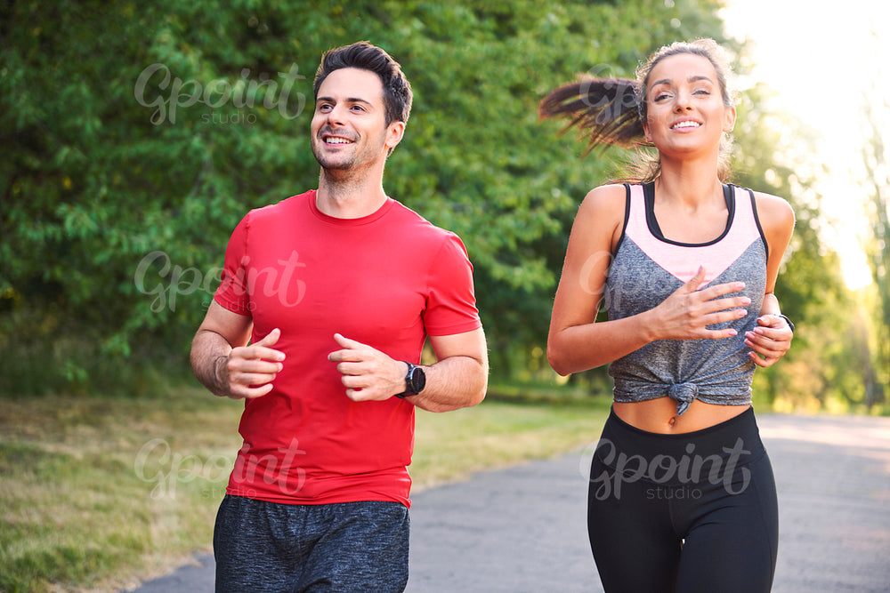 Smiling young couple running in the park