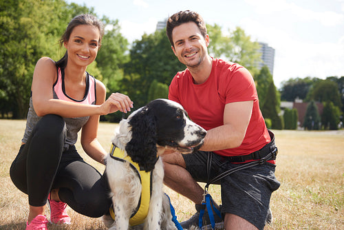 Smiling couple and dog after workout on the fresh air