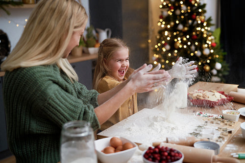 Mother and daughter have fun with flour during Christmas time