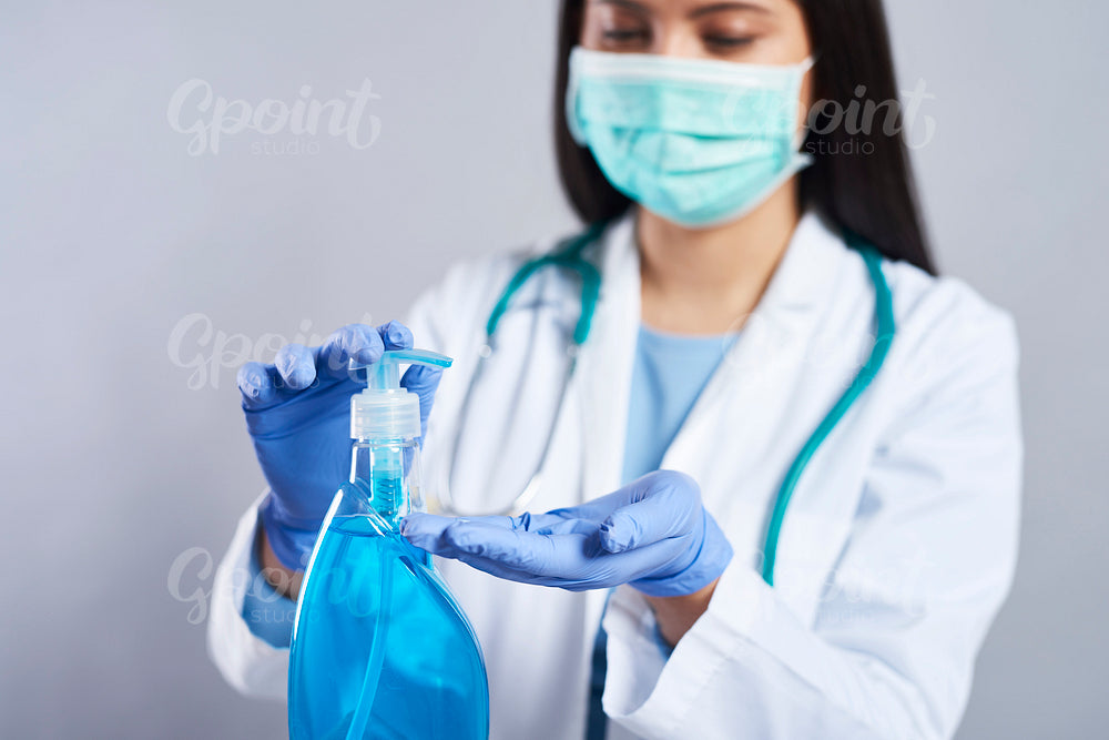 Female doctor using a hand sanitizer