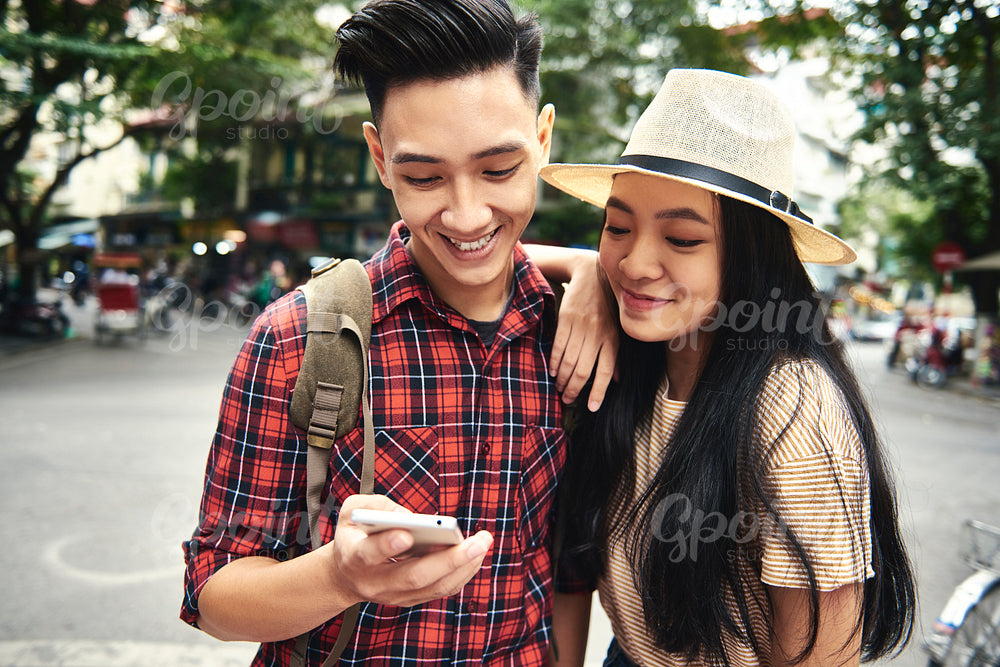 Young couple using mobile phone while traveling