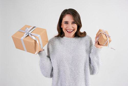 Portrait of beautiful woman holding two gifts in studio shot