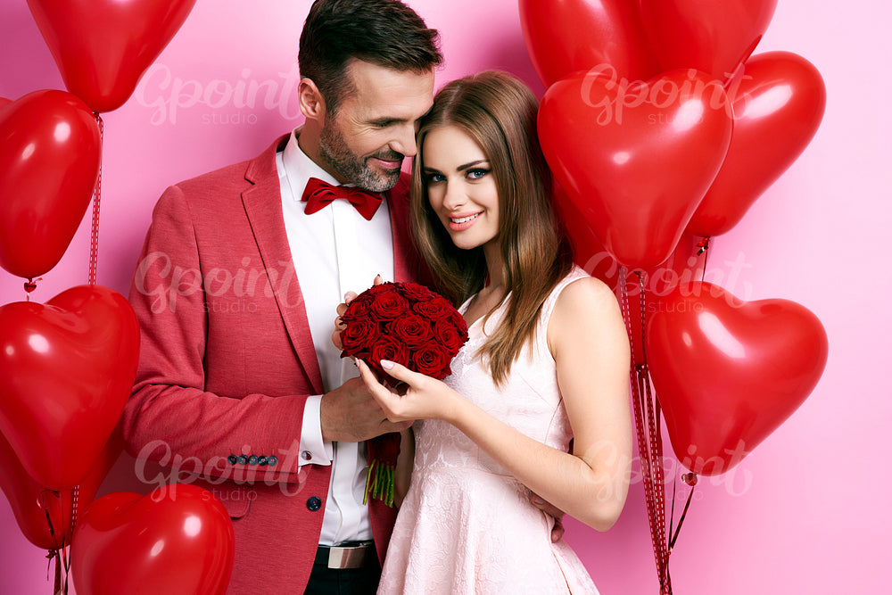 Man giving roses and embracing his girlfriend