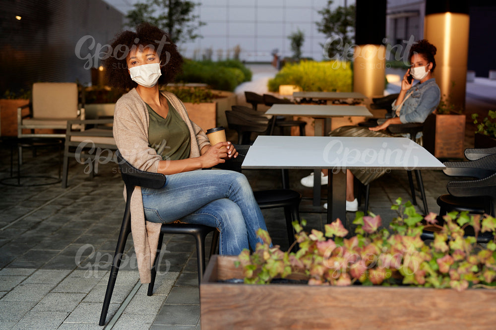People in face mask sitting in a cafe