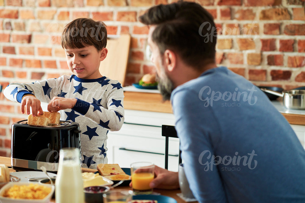 Son helps to prepare breakfast for himself and father