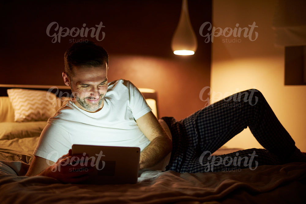 Man using a tablet in bed