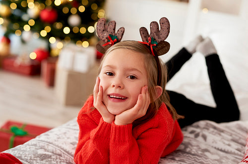 Portrait of girl lying on the bed in Christmas costume